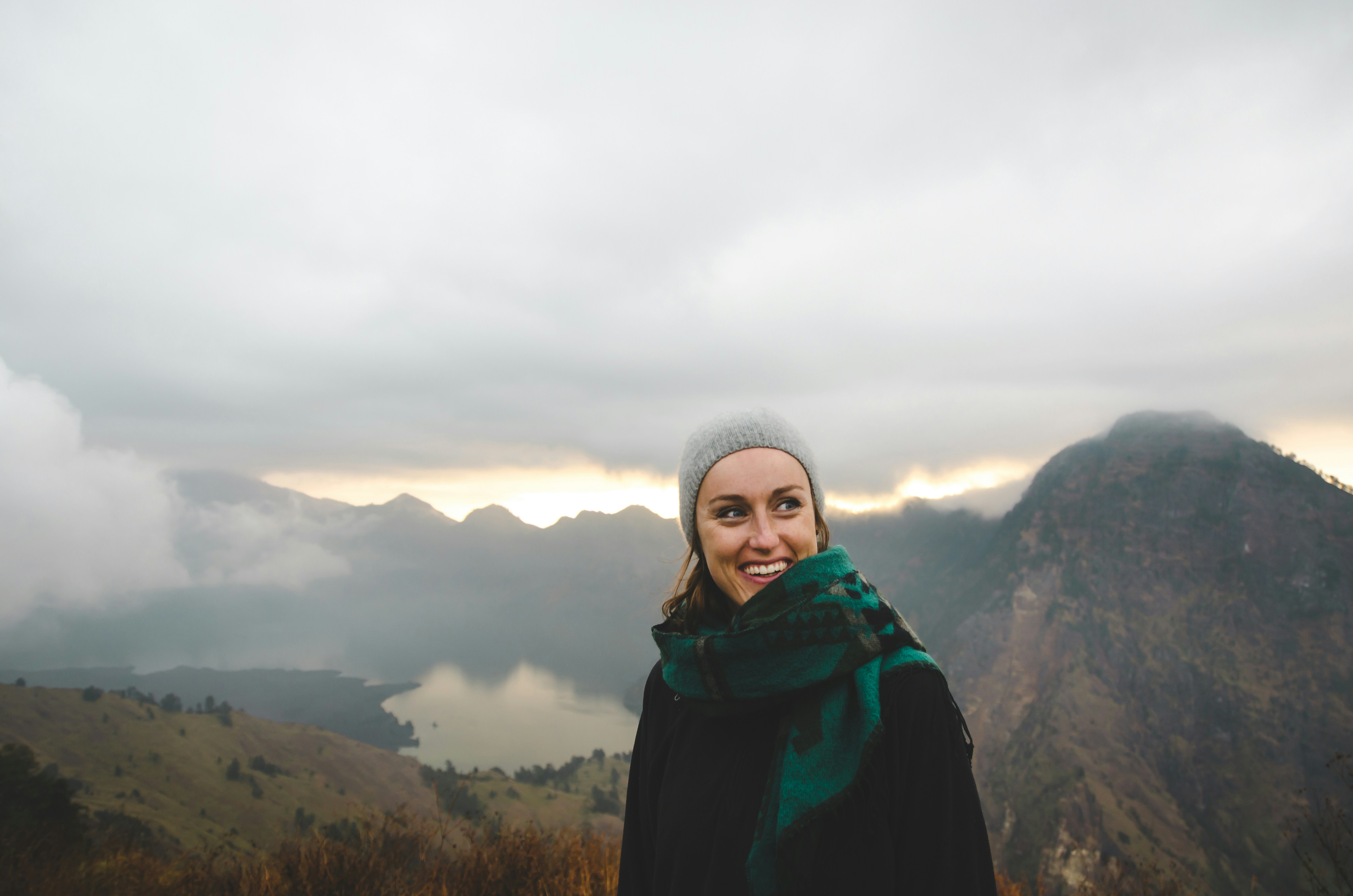 Anais on top of a mountain peak smiling during a sunrise