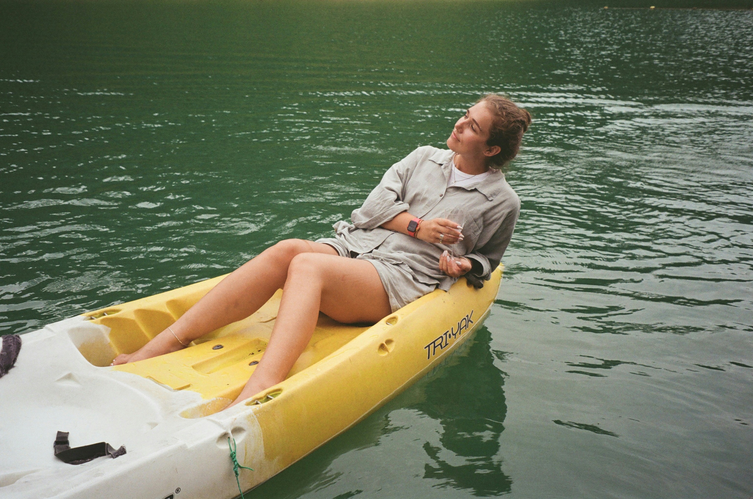 Geraldine relaxing, casually laying back against her kayak in a lake